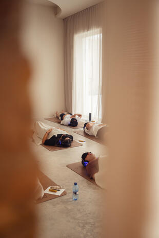 Immersive group experience — Breathwork & Ice Bath Participants lying on yoga mats and wearing headphones during an indoor breathwork session