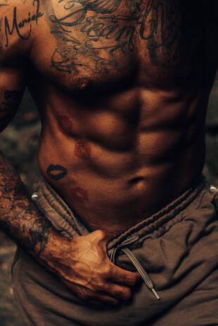 Strength and form Close portrait of a muscular male torso with hands resting near the waistband of jeans